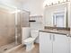 Bathroom with glass-enclosed shower, granite countertop and white cabinets at 390 17Th Nw St # 5031, Atlanta, GA 30363