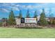 Stone sign for Berkeley Mill neighborhood is enhanced by green bushes and evergreen trees at 1629 Tide Mill Rd, Cumming, GA 30040