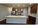 Modern kitchen featuring stainless steel appliances, granite counters and a large kitchen island at 3285 Wild Basil Ln, Buford, GA 30519