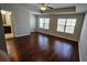 Spacious main bedroom with hardwood floors, two windows, and ceiling fan at 3285 Wild Basil Ln, Buford, GA 30519