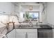 Well-lit kitchen with stainless steel sink and appliances, marble backsplash, plus living room view at 75 14Th Ne St # 3830, Atlanta, GA 30309