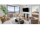 Bright living room featuring a balcony with city views, hardwood floors, and modern furnishings at 75 14Th Ne St # 3830, Atlanta, GA 30309