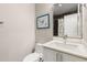 Compact bathroom featuring a toilet, vanity with sink, mirror, and framed art for added elegance at 103 Birch St, Decatur, GA 30030