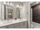 Bright bathroom with a double vanity, modern fixtures, and a door to a shower-tub combo at 103 Birch St, Decatur, GA 30030