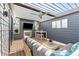 Stylish covered patio with comfortable seating, a fireplace, television, and an outdoor dining area at 103 Birch St, Decatur, GA 30030