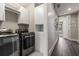 Modern laundry room features a gray front-loading washer/dryer set and white cabinets for optimal storage solutions at 103 Birch St, Decatur, GA 30030