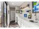 Bright wet bar has white countertops, sink, cabinets, floating shelves, and is lit by natural sunlight at 103 Birch St, Decatur, GA 30030