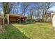 Large backyard featuring a covered garage/outdoor space, mature trees, and a large green lawn at 1277 Mcpherson Se Ave, Atlanta, GA 30316