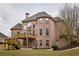 Brick home exterior with a wooden deck, landscaped backyard, and mature trees at 912 Fire Thorn Dr, Hampton, GA 30228