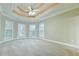 Expansive bedroom with tray ceilings, neutral carpet, and multiple windows for serene light at 912 Fire Thorn Dr, Hampton, GA 30228