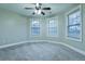 Bright bedroom with neutral carpet, two windows, and a ceiling fan at 912 Fire Thorn Dr, Hampton, GA 30228