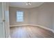 Small, light-filled bedroom with hardwood floors and a window at 912 Fire Thorn Dr, Hampton, GA 30228