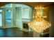 Elegant chandelier hangs above the foyer with gleaming hardwood floors and an inviting fireplace beyond at 912 Fire Thorn Dr, Hampton, GA 30228