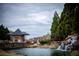 Scenic neighborhood entrance featuring a waterfall, pond, and guard house at 912 Fire Thorn Dr, Hampton, GA 30228