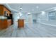 Open kitchen and living area with wooden cabinets, island, stainless steel appliances, and gray wood floors at 912 Fire Thorn Dr, Hampton, GA 30228