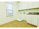 Bright laundry room with white cabinets, a sink, and a window for natural light at 912 Fire Thorn Dr, Hampton, GA 30228