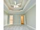 Spacious main bedroom with a tray ceiling, ceiling fan, and neutral carpet at 912 Fire Thorn Dr, Hampton, GA 30228