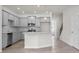 Stylish kitchen with stainless appliances, gray cabinets, a large island, and an adjacent staircase at 313 Skye Ln # 49, Cartersville, GA 30121