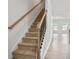 Carpeted staircase with wooden handrail and black iron balusters at 313 Skye Ln # 49, Cartersville, GA 30121