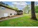 View of backyard with covered porch, manicured lawn, concrete sidewalk and mature trees at 3951 Covered Bridge Sw Rd, Smyrna, GA 30082