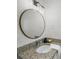 Elegant bathroom features a round mirror, granite countertop, and modern lighting at 3951 Covered Bridge Sw Rd, Smyrna, GA 30082