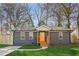 Charming home featuring a newly landscaped yard, gray siding, and a welcoming bright yellow front door at 4179 Hanes Dr, Decatur, GA 30035