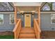 A welcoming covered front porch with a yellow front door and newly stained wood stairs at 4179 Hanes Dr, Decatur, GA 30035