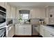 Bright kitchen features white cabinets, granite countertops, stainless steel appliances, and a window offering natural light at 7115 Harbour Lndg, Alpharetta, GA 30005