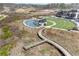 Aerial view of a community featuring a tranquil pond, outdoor amphitheater, and meandering walking paths at 1645 Renfroe Run, Cumming, GA 30041