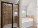 This bathroom boasts a shower, a separate tub, and beautiful tile work throughout the space at 1645 Renfroe Run, Cumming, GA 30041