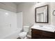 Cozy bathroom featuring a shower-tub combo, a dark-wood vanity, and neutral paint at 1645 Renfroe Run, Cumming, GA 30041
