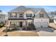 Charming two-story home featuring a well-manicured lawn and an inviting front porch at 1645 Renfroe Run, Cumming, GA 30041