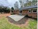 The backyard of a red brick house features a concrete patio and green space at 4430 Locksley Rd, Tucker, GA 30084