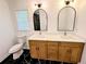 Bathroom with a wood double sink vanity, white counters, and black and white marble-like floors at 4430 Locksley Rd, Tucker, GA 30084