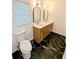 Modern bathroom with dual sinks, wood cabinets, quartz counters, and beautiful black-and-white tile floor at 4430 Locksley Rd, Tucker, GA 30084