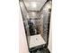 Elegant shower with black marble-like tiles, white hexagon floor tiles, and glass doors at 4430 Locksley Rd, Tucker, GA 30084