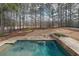 Aerial view of the sparkling pool, putting green, and sprawling backyard with towering trees at 151 Creek Bank Dr, Acworth, GA 30101