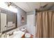 This bathroom has a wide mirror over the sink, wainscotting, and a closet and shower with a curtain at 151 Creek Bank Dr, Acworth, GA 30101