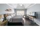 This spacious bedroom features a ceiling fan, dark wood floors, tray ceilings, and a charming sitting area at 151 Creek Bank Dr, Acworth, GA 30101