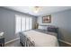 A cozy bedroom featuring natural light, neutral walls, a ceiling fan, and plantation shutters on the window at 151 Creek Bank Dr, Acworth, GA 30101