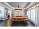 Dining room with wooden table and bench seating, stylish light fixture, and bright windows at 151 Creek Bank Dr, Acworth, GA 30101