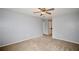 Large bedroom featuring new carpet, neutral paint, ceiling fan, and a hallway to the bathroom at 3301 Henderson Mill Rd # F1, Atlanta, GA 30341
