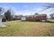 Expansive backyard with a red brick home, spacious lawn, and mature trees at 5205 Dunmoreland Ct, Atlanta, GA 30349