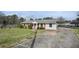 Charming single-story home with a spacious front yard and a long concrete driveway leading to a covered carport at 5205 Dunmoreland Ct, Atlanta, GA 30349