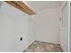 A functional laundry room featuring a wooden shelf and neutral tile flooring at 5205 Dunmoreland Ct, Atlanta, GA 30349