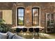 Modern dining room featuring a long wooden table, black chairs, exposed brick, and large windows with natural light at 170 Boulevard Se # H523, Atlanta, GA 30312