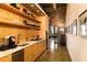 Modern kitchen with stainless steel appliances, light wood cabinets, open shelving, and exposed brick accent wall at 170 Boulevard Se # H523, Atlanta, GA 30312
