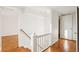 Hallway with hardwood floors, white walls, railing, and access to other rooms at 2654 Jefferson Ter, Atlanta, GA 30344