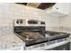 Close-up of stainless steel oven/stove top with granite countertops and tile backsplash at 2654 Jefferson Ter, Atlanta, GA 30344