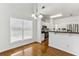Bright dining room with hardwood floors, modern lighting, and large window overlooking the kitchen with stainless steel appliances at 3277 Wyesham Cir, Duluth, GA 30096